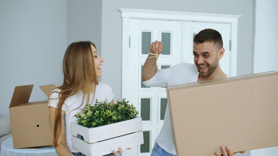 Couple carrying boxes and keys